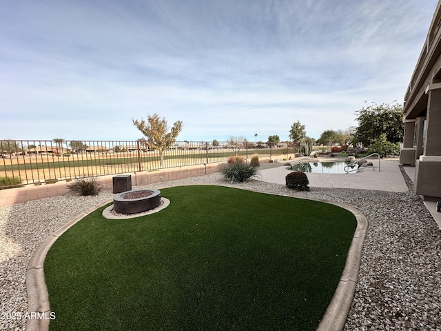 view of yard with a fenced in pool, a fire pit, a patio, and a water view