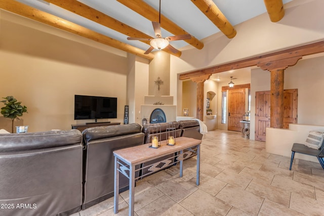 living room featuring ceiling fan, decorative columns, and beam ceiling