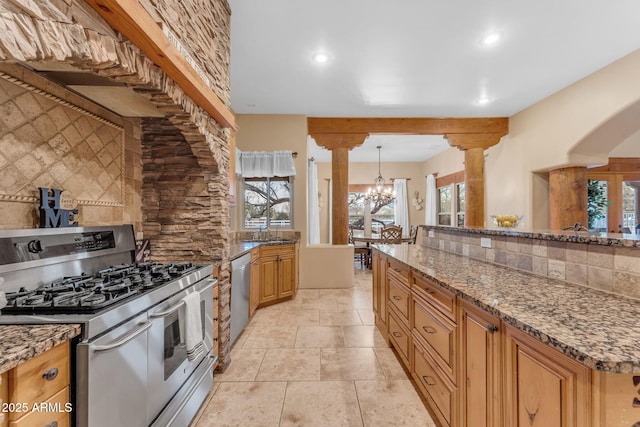 kitchen with stainless steel appliances, dark stone counters, tasteful backsplash, hanging light fixtures, and a notable chandelier