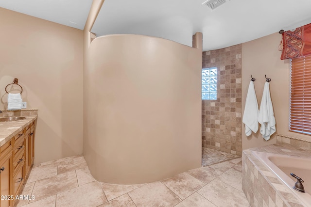 bathroom with vanity and a relaxing tiled tub