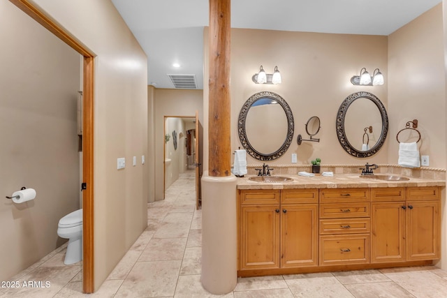 bathroom featuring toilet, vanity, and tile patterned flooring