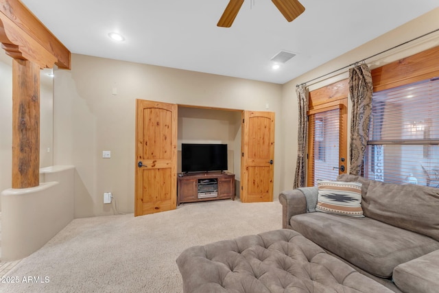 carpeted living room with ceiling fan