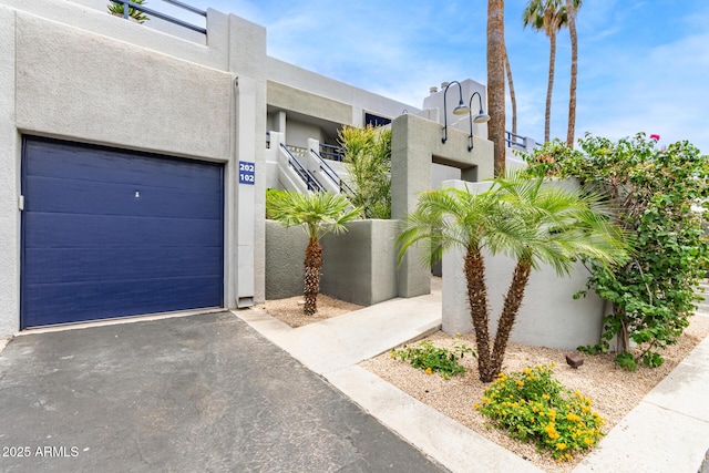 902 W Glendale Ave Unit 102, Phoenix, AZ 85021 - view of front of property featuring stucco siding, a garage, and asphalt driveway