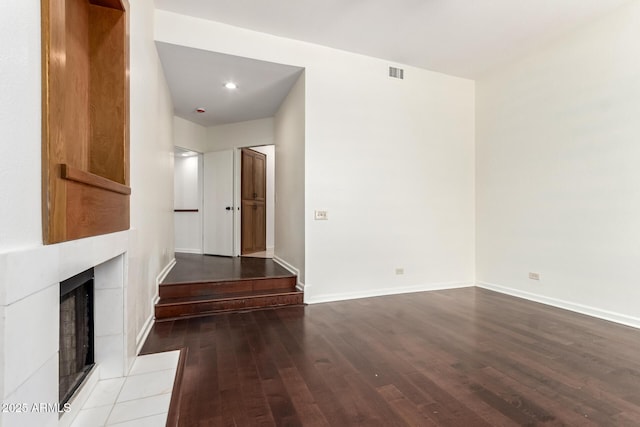 902 W Glendale Ave Unit 102, Phoenix, AZ 85021 - spare room with wood-type flooring, a tiled fireplace, and baseboards