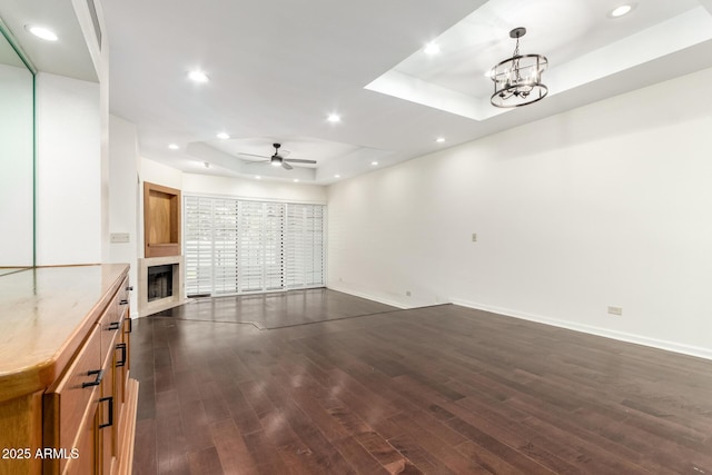 902 W Glendale Ave Unit 102, Phoenix, AZ 85021 - unfurnished living room with a raised ceiling, dark wood finished floors, baseboards, recessed lighting, and ceiling fan