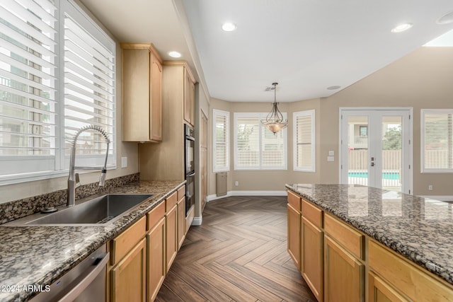 kitchen featuring appliances with stainless steel finishes, dark stone counters, dark parquet floors, sink, and decorative light fixtures