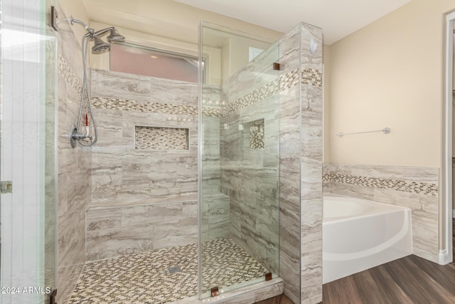 bathroom with shower with separate bathtub and hardwood / wood-style flooring