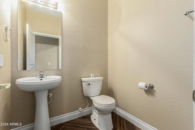 bathroom featuring sink, wood-type flooring, and toilet