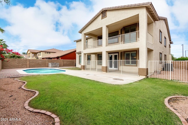 back of house with a lawn, a patio area, and a fenced in pool