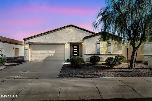 1747 E Grove St, Phoenix, AZ 85040 - mediterranean / spanish house featuring stucco siding, a garage, driveway, and a tile roof