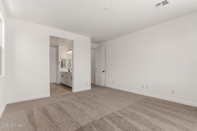 40563 W Michaels Dr, Maricopa, AZ 85138 - unfurnished bedroom featuring light colored carpet, baseboards, and connected bathroom
