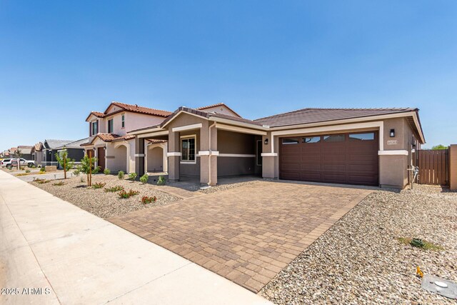 40563 W Michaels Dr, Maricopa, AZ 85138 - view of front facade featuring decorative driveway, a tiled roof, an attached garage, and stucco siding