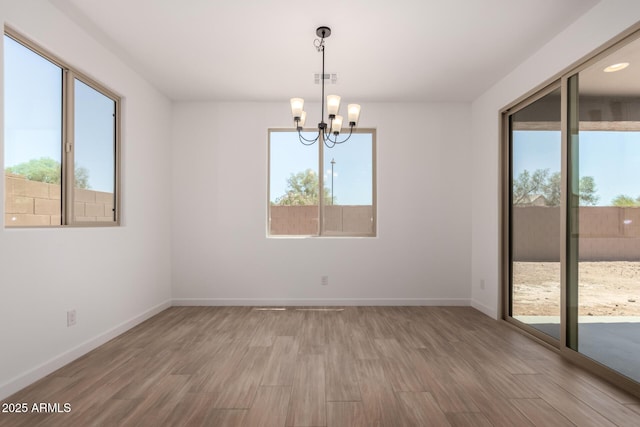 40563 W Michaels Dr, Maricopa, AZ 85138 - unfurnished room featuring healthy amount of natural light, a chandelier, and wood finished floors