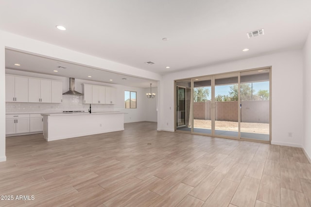 40563 W Michaels Dr, Maricopa, AZ 85138 - unfurnished living room featuring healthy amount of natural light, a chandelier, recessed lighting, and light wood-style flooring