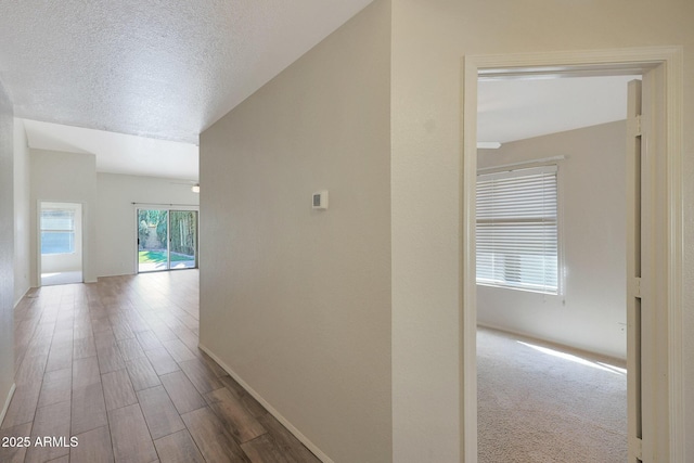 hallway featuring wood-type flooring and a textured ceiling