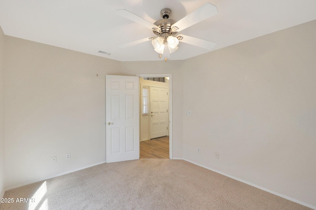 carpeted spare room featuring ceiling fan