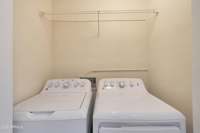 clothes washing area with washing machine and dryer