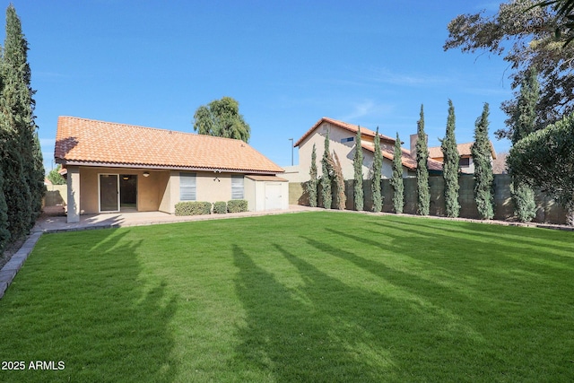 rear view of house with a shed, a patio area, and a lawn