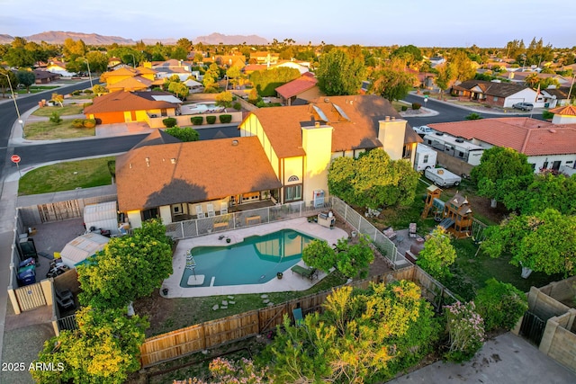 aerial view of residential area with a pool and a mountain backdrop