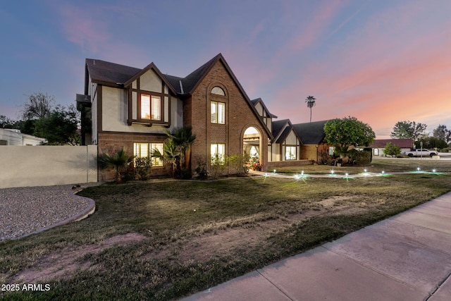tudor home with brick siding and driveway