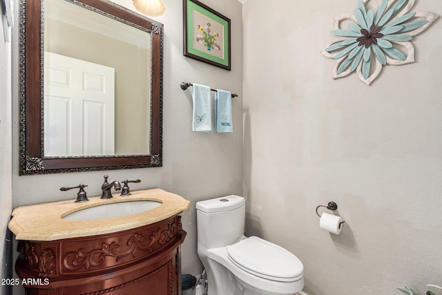 half bath featuring vanity and toilet