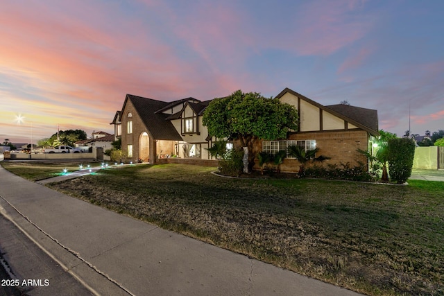 view of front of home featuring a front lawn, stucco siding, and brick siding