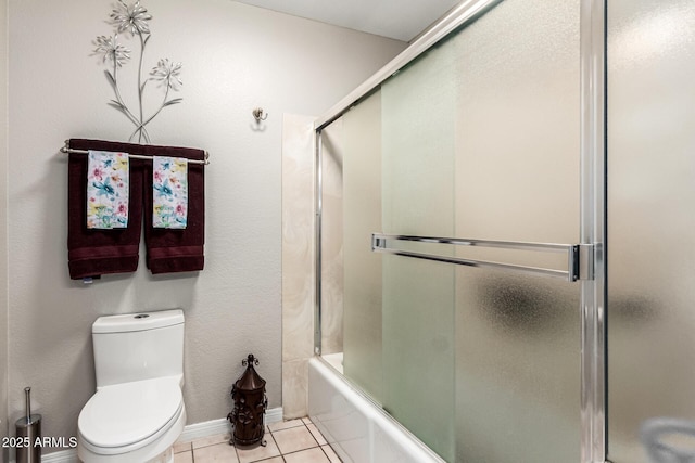 bathroom featuring toilet, tile patterned flooring, and enclosed tub / shower combo