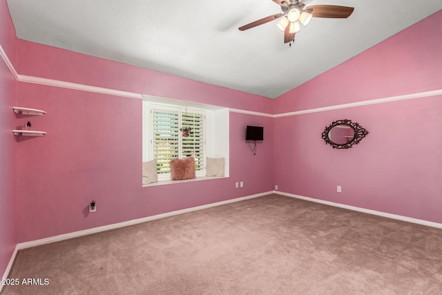 empty room featuring carpet floors, a ceiling fan, vaulted ceiling, and baseboards
