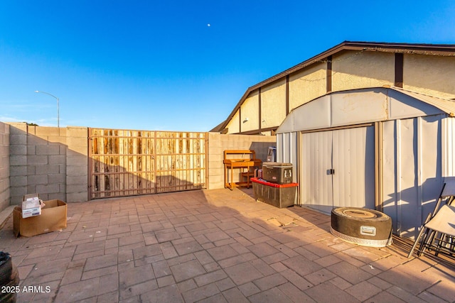 view of patio / terrace with a storage shed, an outbuilding, and a fenced backyard