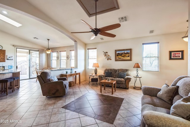 living room with ceiling fan, light tile patterned floors, and vaulted ceiling