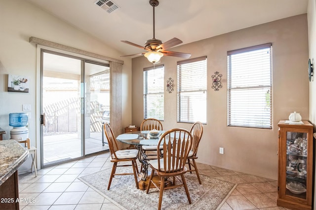 dining area with light tile patterned floors, vaulted ceiling, and ceiling fan