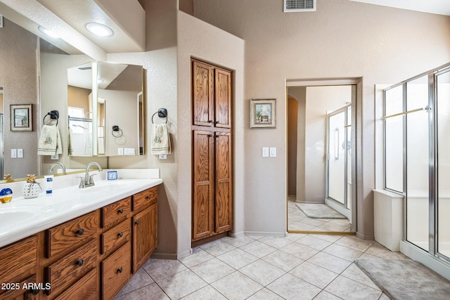 bathroom featuring tile patterned floors, vanity, and an enclosed shower