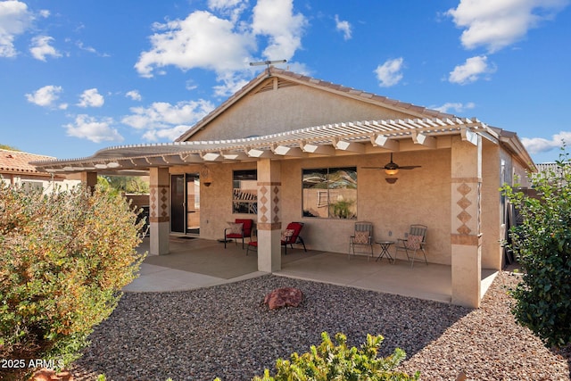 rear view of property with ceiling fan and a patio