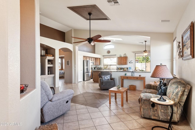 tiled living room featuring built in shelves, ceiling fan, and lofted ceiling