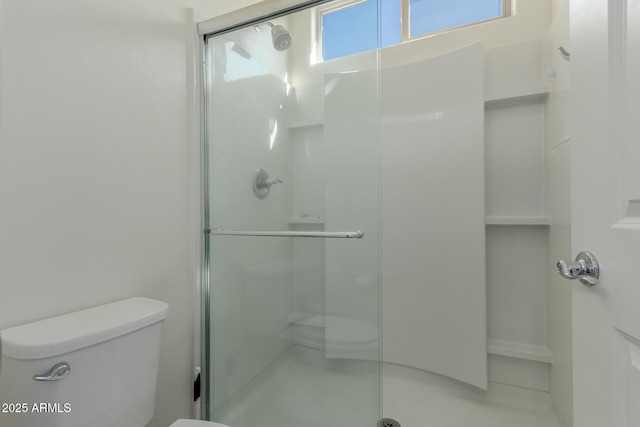 bathroom with a wealth of natural light, toilet, and an enclosed shower