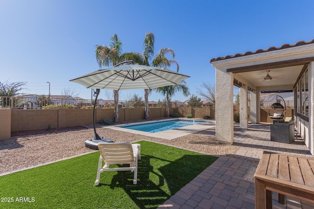 view of pool featuring ceiling fan, a patio area, and a lawn