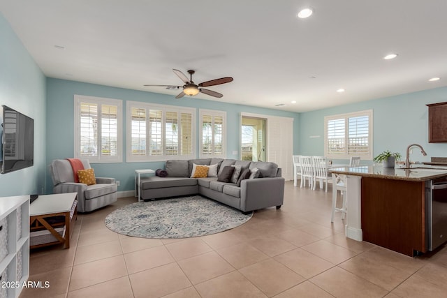 tiled living room featuring ceiling fan and sink