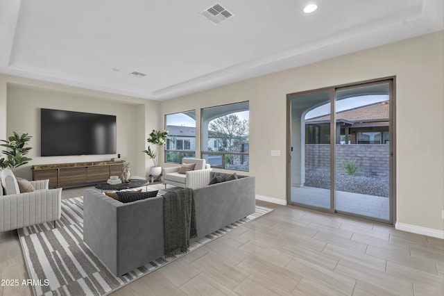 living room featuring a healthy amount of sunlight, baseboards, and visible vents