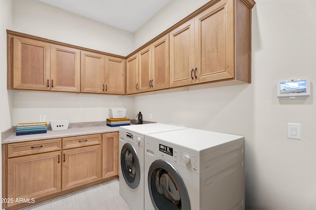 clothes washing area featuring cabinet space and independent washer and dryer