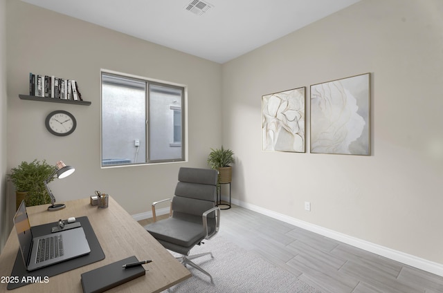 office area with wood finished floors, visible vents, and baseboards