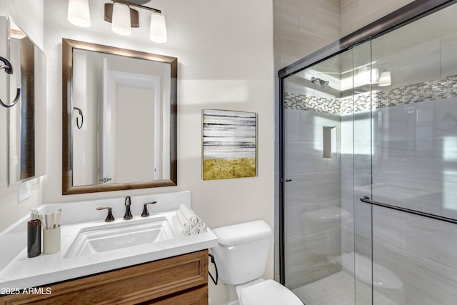 bathroom featuring toilet, a stall shower, and vanity