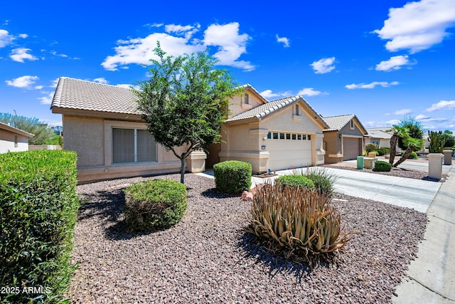 15194 W Vale Dr, Goodyear, AZ 85395 - view of front facade with a tiled roof, a garage, stucco siding, and driveway