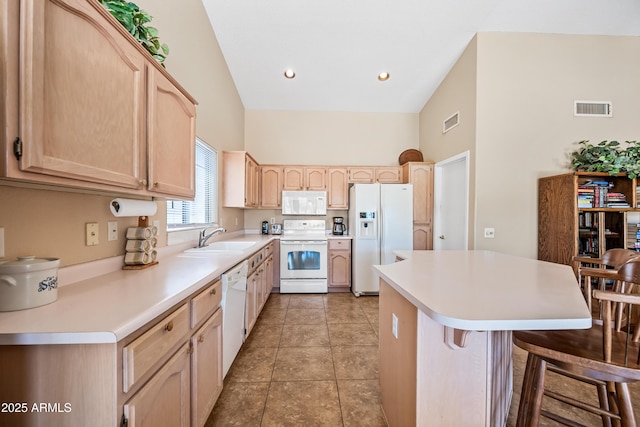 15194 W Vale Dr, Goodyear, AZ 85395 - kitchen featuring white appliances, light brown cabinetry, a breakfast bar area, a high ceiling, and a kitchen island