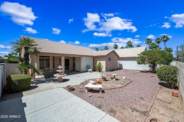 15194 W Vale Dr, Goodyear, AZ 85395 - view of front of home featuring a tiled roof, a patio, a fenced backyard, and stucco siding