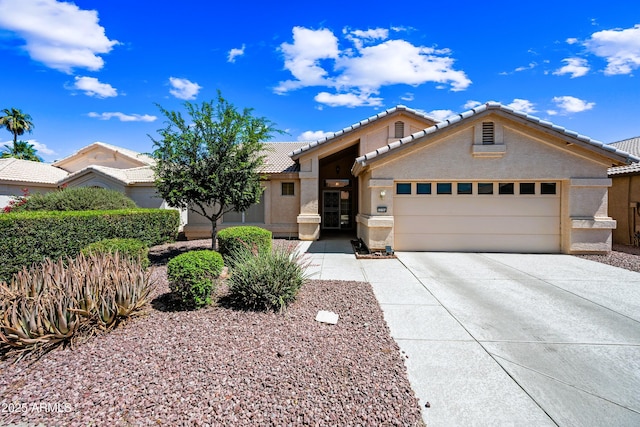 15194 W Vale Dr, Goodyear, AZ 85395 - view of front of house with a tile roof, a garage, stucco siding, and concrete driveway