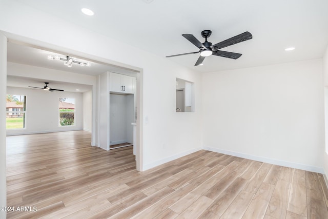 spare room with ceiling fan and light wood-type flooring