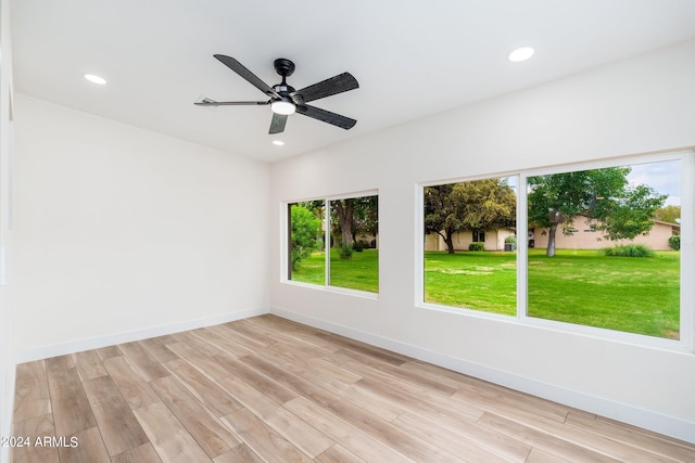 empty room with ceiling fan, light hardwood / wood-style floors, and a wealth of natural light