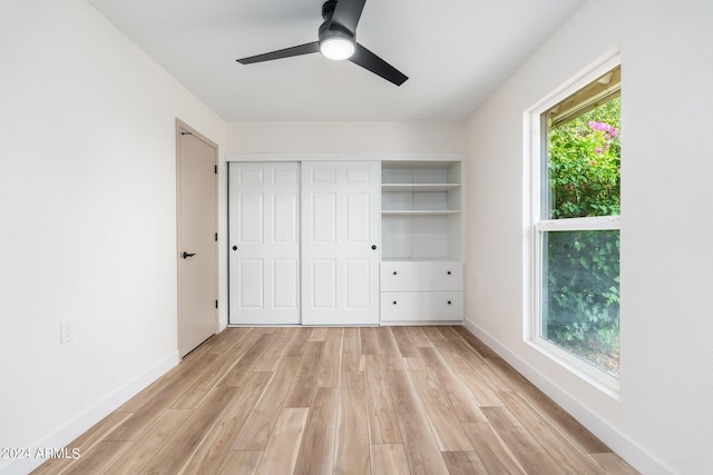 unfurnished bedroom featuring ceiling fan, light wood-type flooring, and a closet