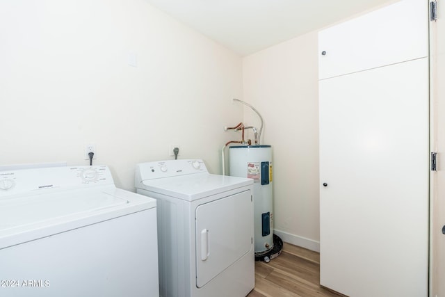 laundry room featuring light wood-type flooring, washer and clothes dryer, and water heater