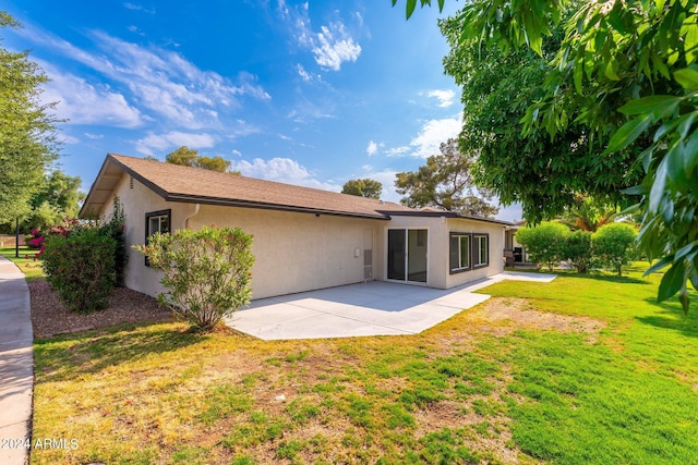 back of house featuring a patio and a lawn